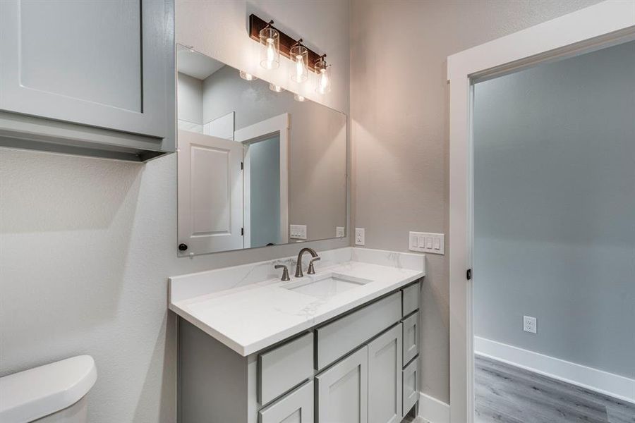 Bathroom with vanity, hardwood / wood-style floors, and toilet