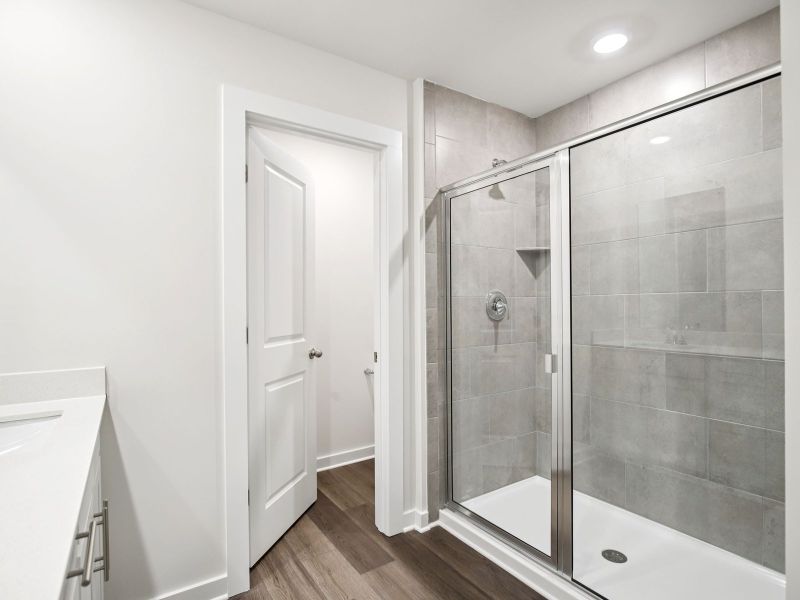 The primary bathroom offers dual vanity sinks and a walk-in shower.