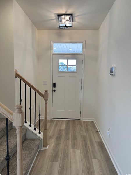 Foyer entrance featuring light wood-style floors and stairs