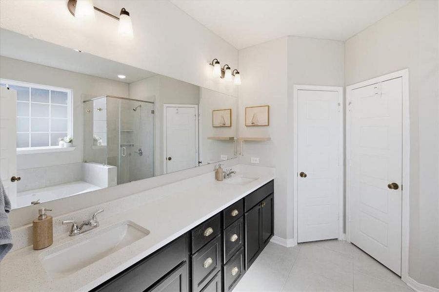 Bathroom featuring double vanity, a walk-in shower, garden tub, and light tile patterned flooring Bathroom featuring double vanity, a walk-in shower, garden tub, and light tile patterned flooring