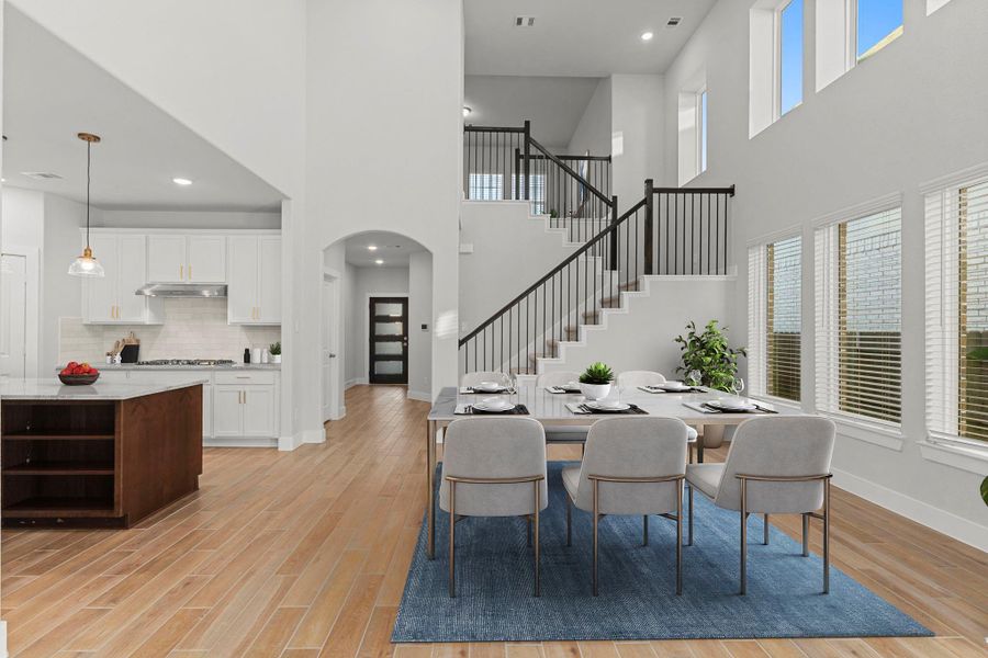 A view from the family area highlights the stunning open-concept flow, connecting the living, dining, and kitchen spaces in one bright and cohesive design. *Staged Photo* A view from the family area highlights the stunning open-concept flow, connecting the living, dining, and kitchen spaces in one bright and cohesive design. *Staged Photo*