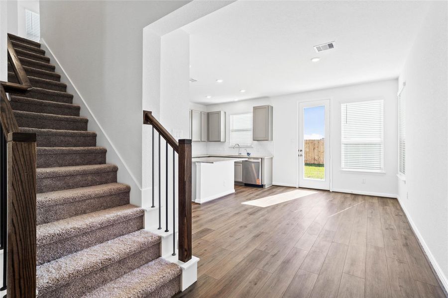 The staircase is enhanced with carpet, wrought iron spindles, and wood hand rail stained in walnut!