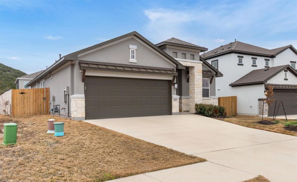 Modern facade with mixed materials welcomes you home to a functional garage and neatly kept grounds.