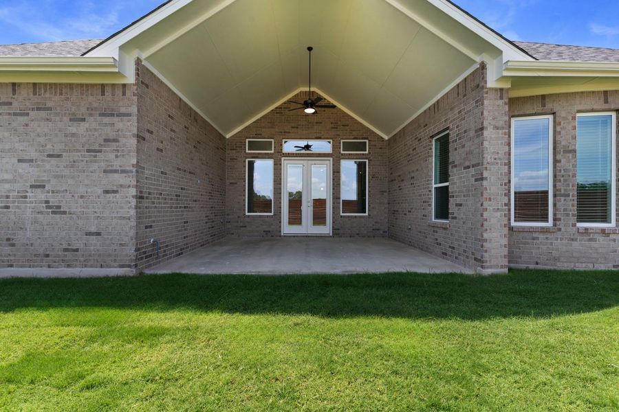 A spacious covered patio provides an ideal setting for outdoor entertaining, seamlessly connecting to the home's interior through elegant double doors.