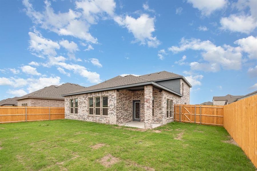 Back of property with a yard and a patio