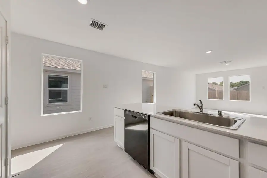 Kitchen with white cabinetry, recessed lighting, black dishwasher, and light wood-type flooring