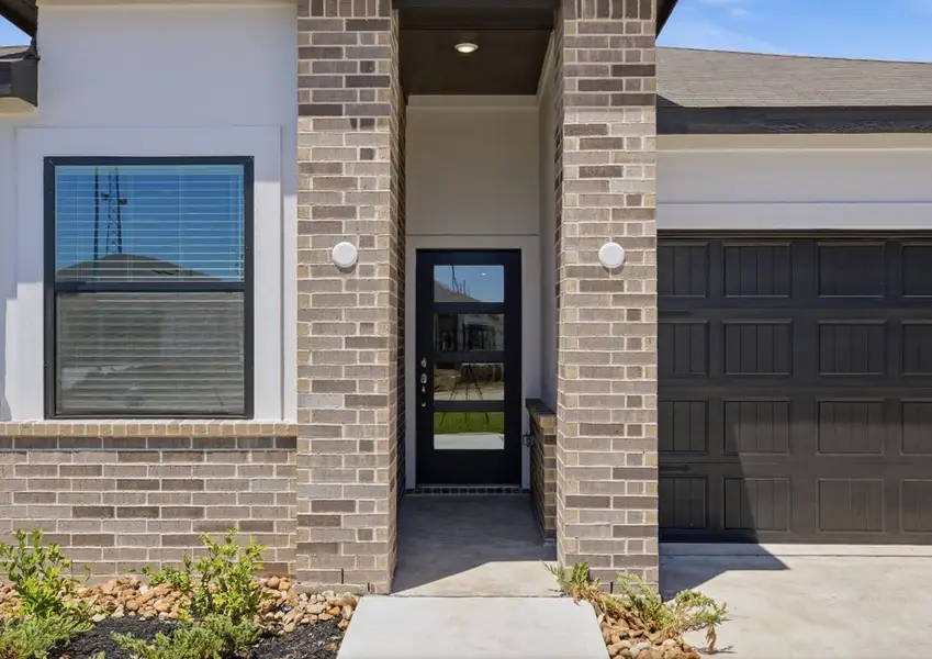 Covered front porch with modern glass door on Montgomery floor plan in Hallimore Ranch