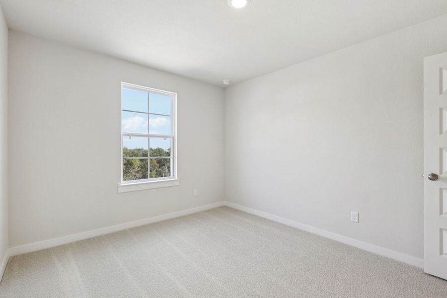 A room with a window and a white wall.