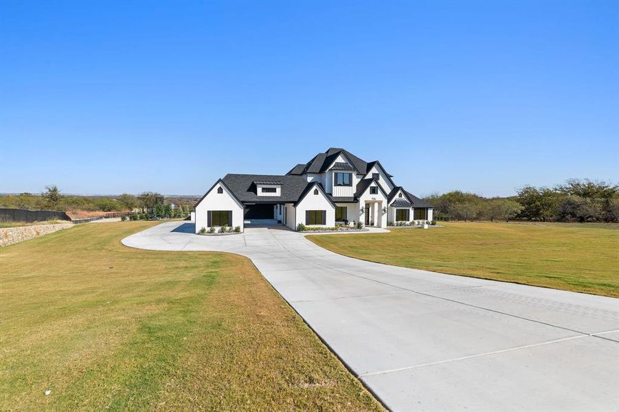 Modern farmhouse style home with driveway, a front yard, and a garage Modern farmhouse style home with driveway, a front yard, and a garage