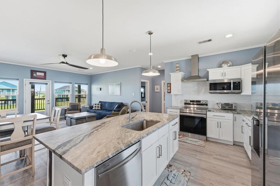 Bright and inviting open-concept kitchen and living area with modern appliances, sleek countertops, and ample natural light leading to a cozy dining space and outdoor views. Bright and inviting open-concept kitchen and living area with modern appliances, sleek countertops, and ample natural light leading to a cozy dining space and outdoor views.