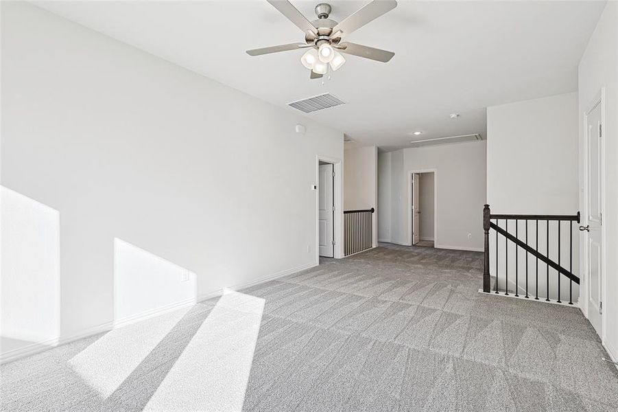 Carpeted empty room featuring ceiling fan