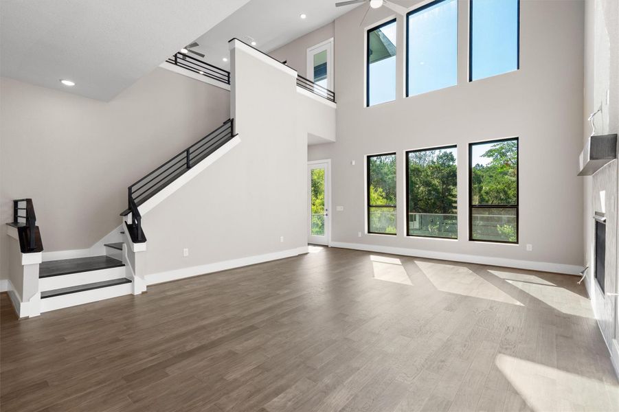A soaring double-height living area features abundant natural light and an elegant modern staircase. A soaring double-height living area features abundant natural light and an elegant modern staircase.