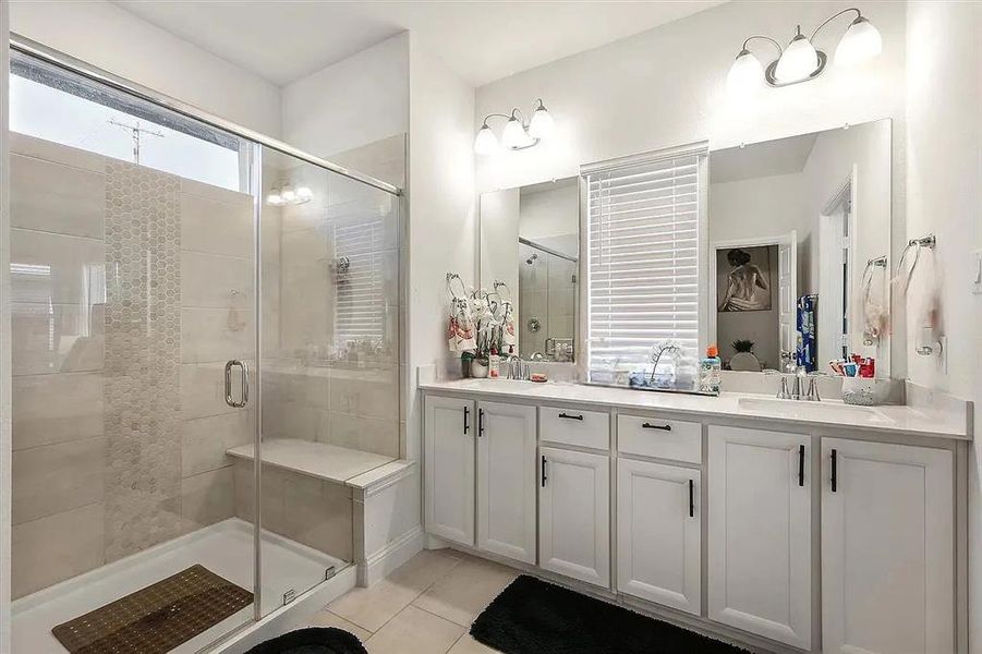 Bathroom featuring vanity, tile patterned floors, and an enclosed shower