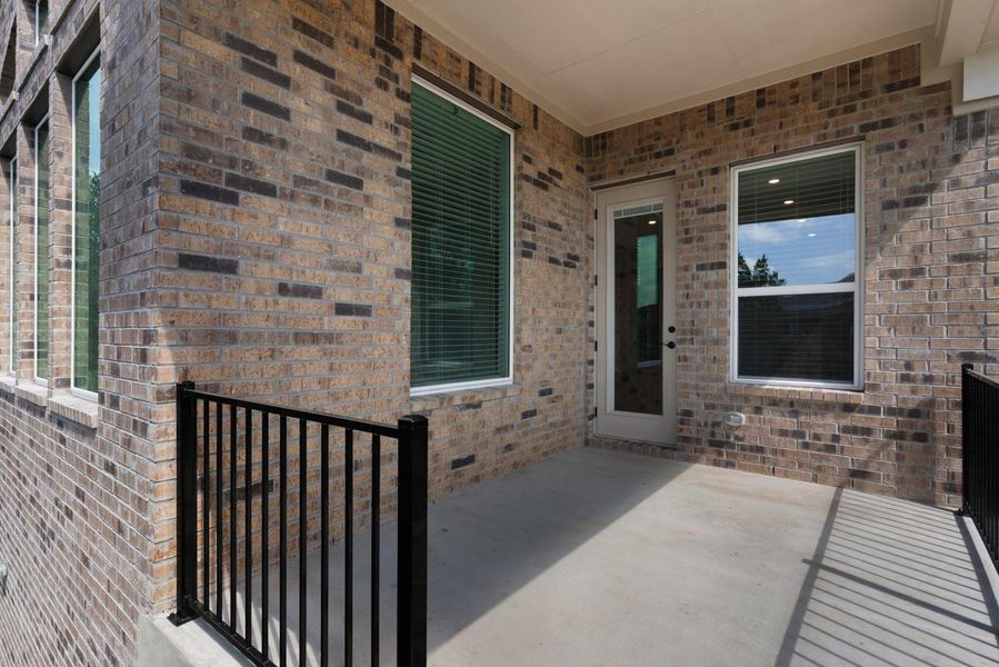A well-lit, private patio extends from the brick-clad structure, offering a versatile outdoor area.