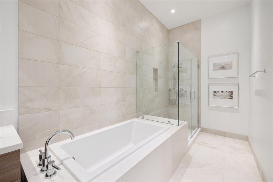 Full porcelain tile surround in tub and shower area.  Separate shower includes hand-held sprayer, bench seat and built-in niche.