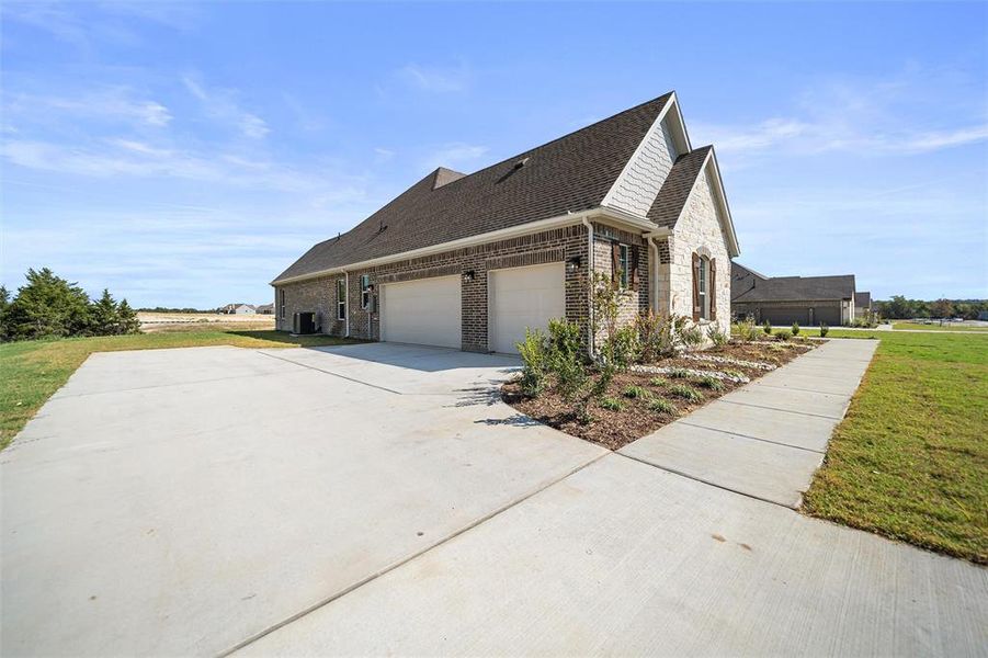 View of property exterior with a shingled roof, brick siding, a lawn, and concrete driveway View of property exterior with a shingled roof, brick siding, a lawn, and concrete driveway