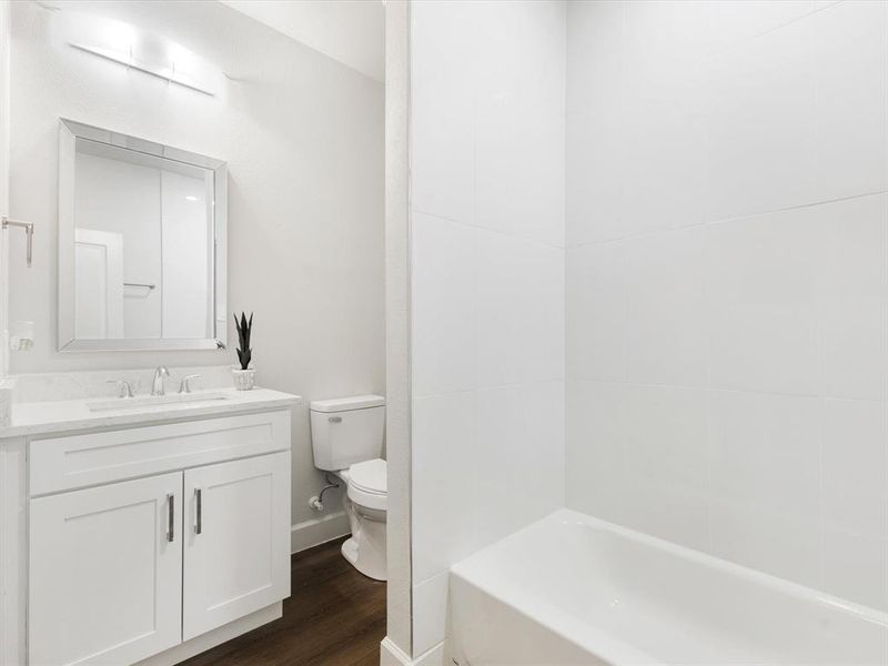 Full bathroom featuring vanity and dark wood-type flooring