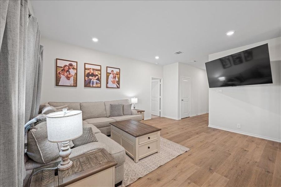 Living area with light wood-style floors and recessed lighting Living area with light wood-style floors and recessed lighting