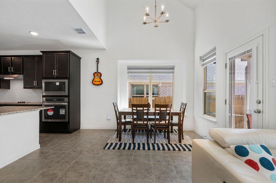 Dining space with suspended lighting and a high ceiling Dining space with suspended lighting and a high ceiling