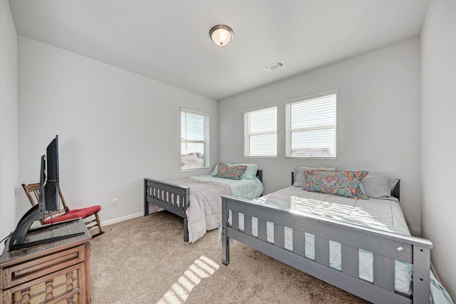 Bedroom with light colored carpet and baseboards
