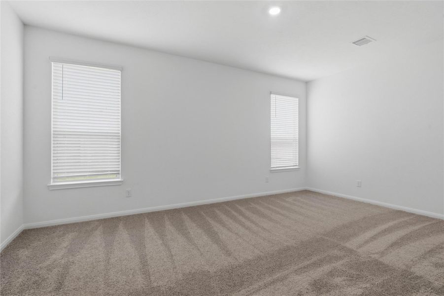 Relax and recharge in this stunning primary suite! This expansive room offers plush carpeting, neutral-toned walls, high ceilings, and large windows with fitted blinds—perfect for unwinding after a long day.
