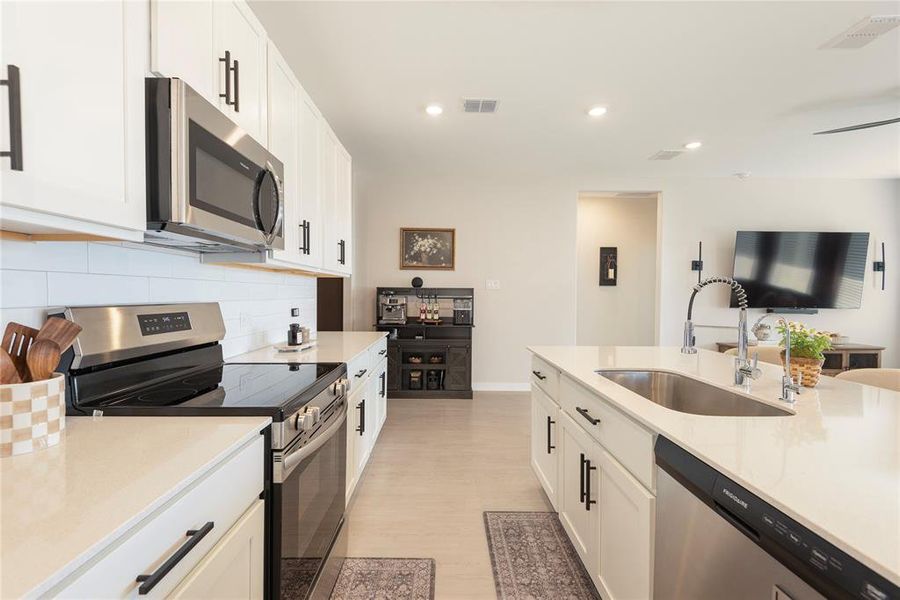 Modern kitchen featuring an island with an undermount sink and gooseneck faucet Modern kitchen featuring an island with an undermount sink and gooseneck faucet