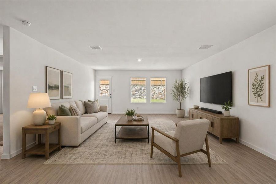 Open concept living area featuring light wood-finish flooring, white walls, and recessed lighting