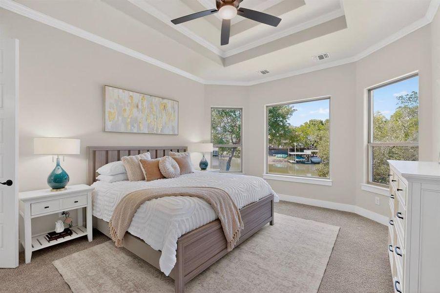 Bedroom with a tray ceiling and a ceiling fan