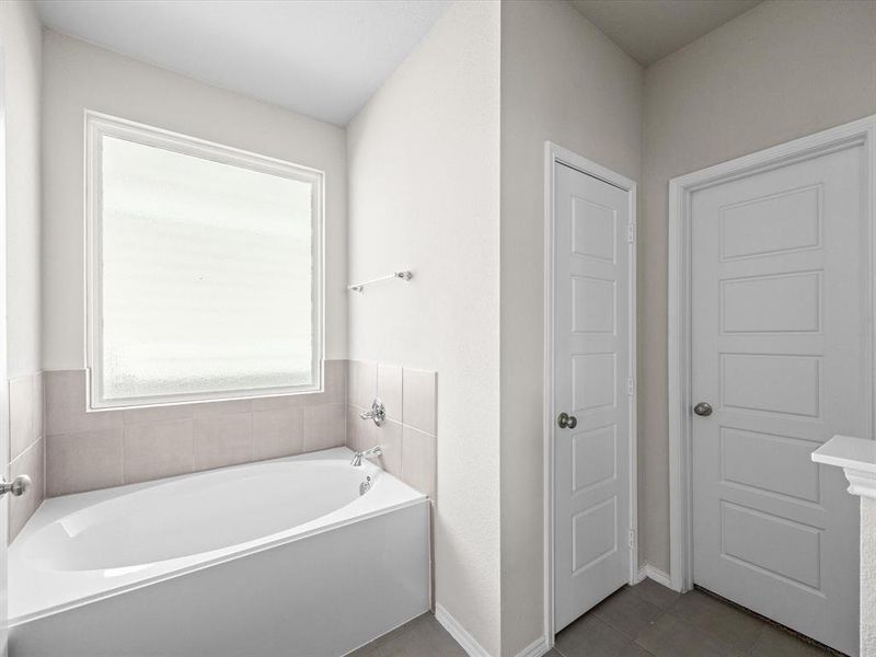 Full bath with a bath and dark tile patterned floors Full bath with a bath and dark tile patterned floors