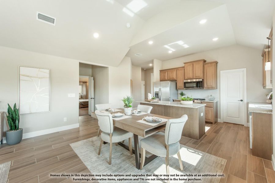 Open-concept dining area and kitchen with wood-look tile floors, vaulted ceiling, and center island with stainless appliances