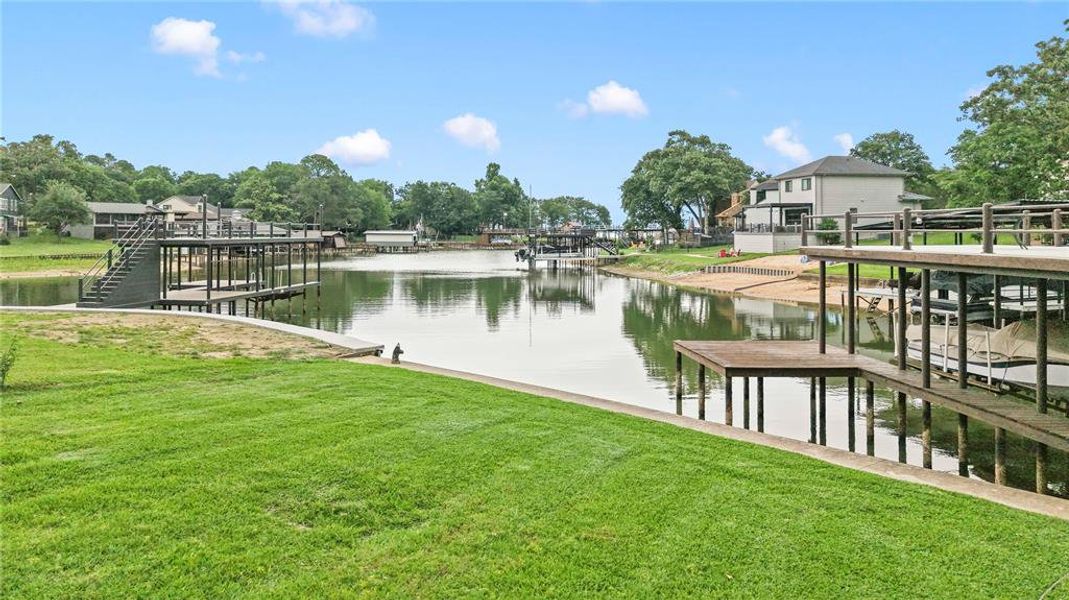 Serene waterfront view of a protected, calm-water cove with a manicured lawn and clean, improved shoreline.