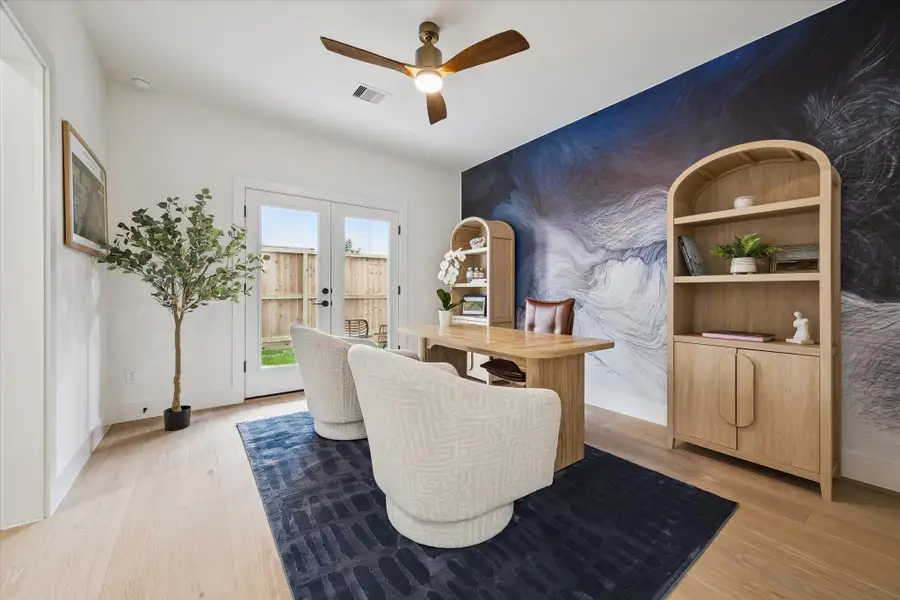 A first-floor secondary bedroom featuring beautiful hardwood floors and direct backyard access—also ideal as a private home office or study.