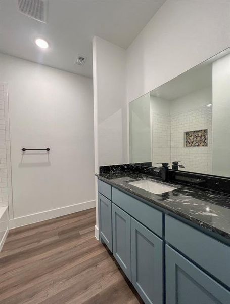 Bathroom featuring tub / shower combination, vanity, and hardwood / wood-style floors