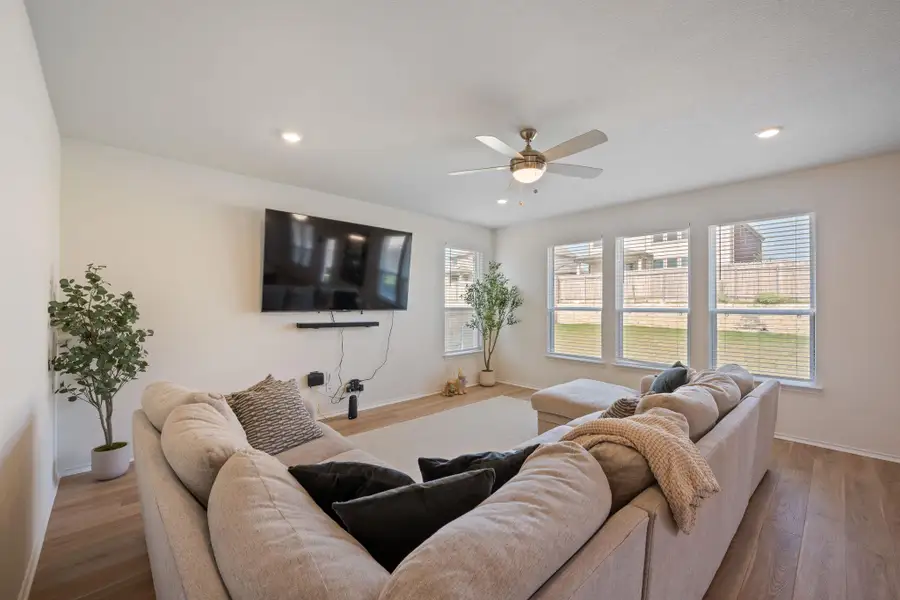 Living area featuring wood finished floors, a ceiling fan, and recessed lighting Living area featuring wood finished floors, a ceiling fan, and recessed lighting