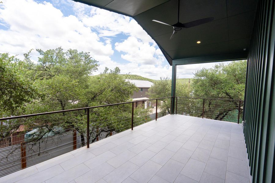 Apartment balcony: An airy deck with a ceiling fan overlooks a serene, tree-filled landscape. Apartment balcony: An airy deck with a ceiling fan overlooks a serene, tree-filled landscape.