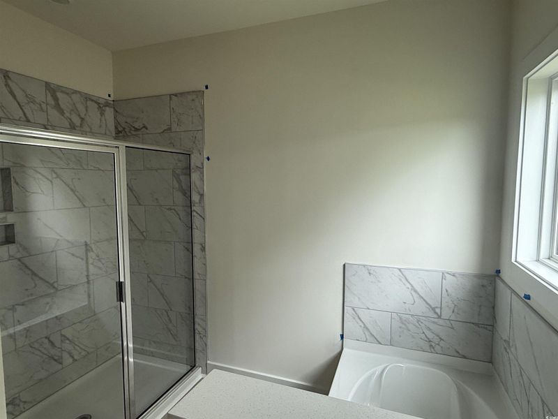 Full bath with a shower stall and a bath