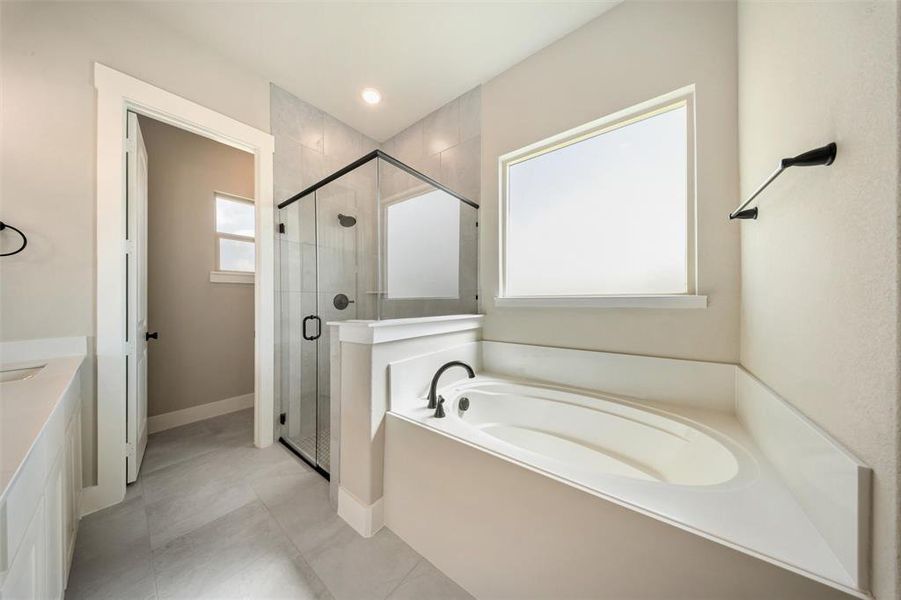 Full bath featuring a bath, a stall shower, and vanity Full bath featuring a bath, a stall shower, and vanity