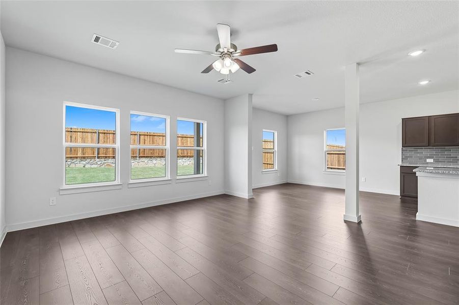 Unfurnished living room with dark wood-style flooring, a ceiling fan, and recessed lighting Unfurnished living room with dark wood-style flooring, a ceiling fan, and recessed lighting