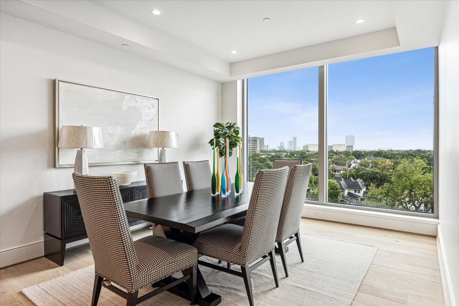 Floor-to-ceiling windows in the formal dining area flood the space with natural light and showcase stunning city Southern views. Photos are of a similar unit with the same floor plan