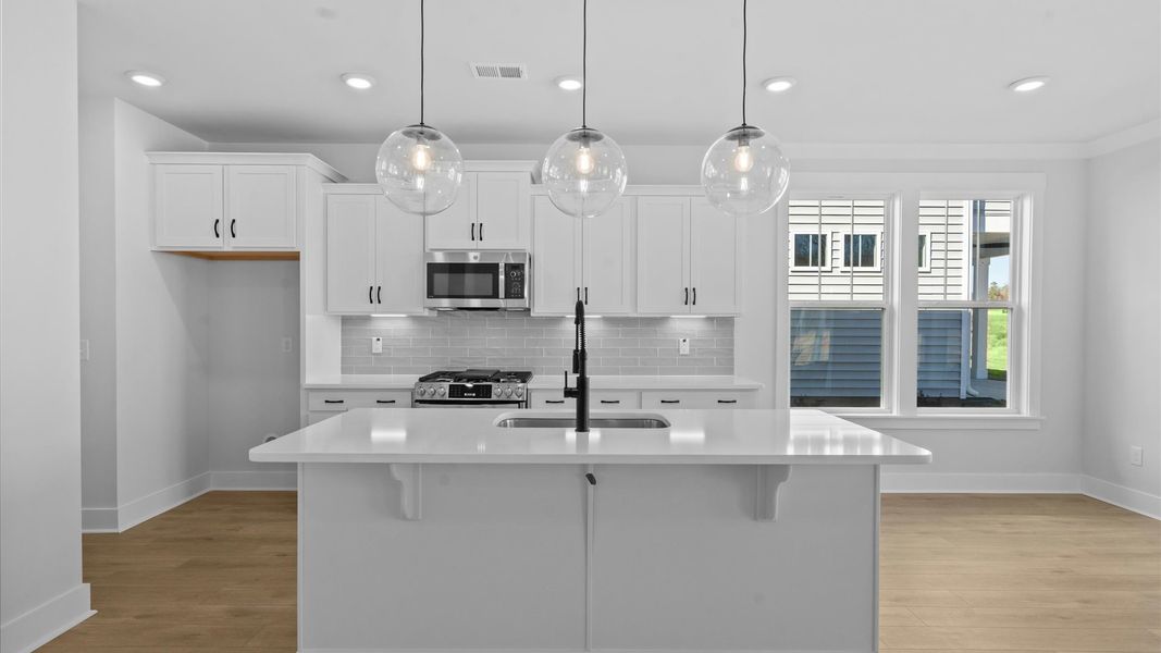 First-rate kitchen with functional layout, designer pendant lighting, and a large center island