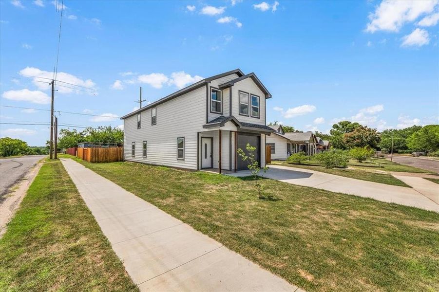 View of side of home featuring concrete driveway and an attached garage