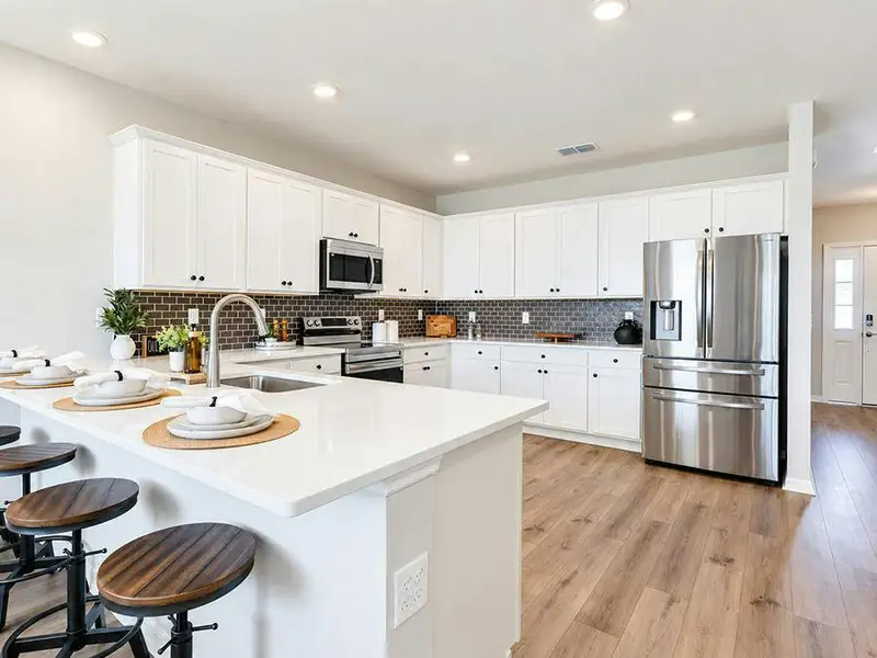 Your bright, open kitchen offers ample cabinet and counter space, along with a large pantry - Wayfair III by Highland Homes
