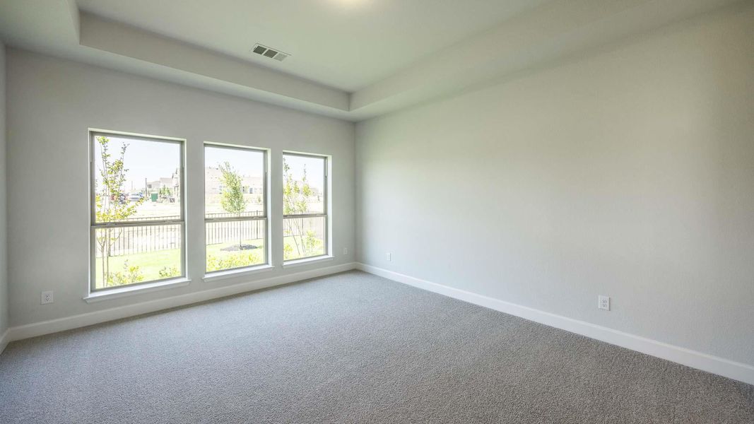 Carpeted empty room with baseboards and visible vents Carpeted empty room with baseboards and visible vents