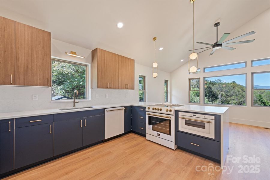 Modern finishes and stylish design throughout the kitchen which features Forno appliances and waterfall quartz counter.