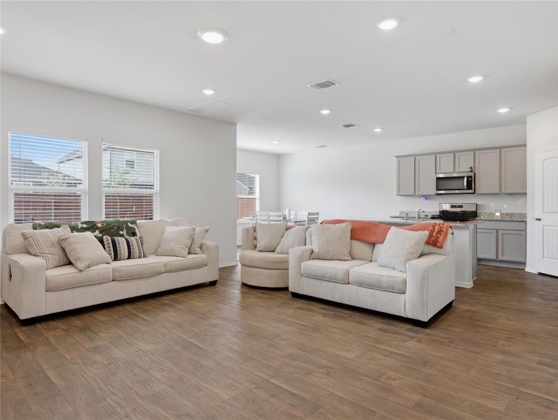 Warm wood-look flooring and crisp recessed lighting enhance this airy open-concept living space. Warm wood-look flooring and crisp recessed lighting enhance this airy open-concept living space.