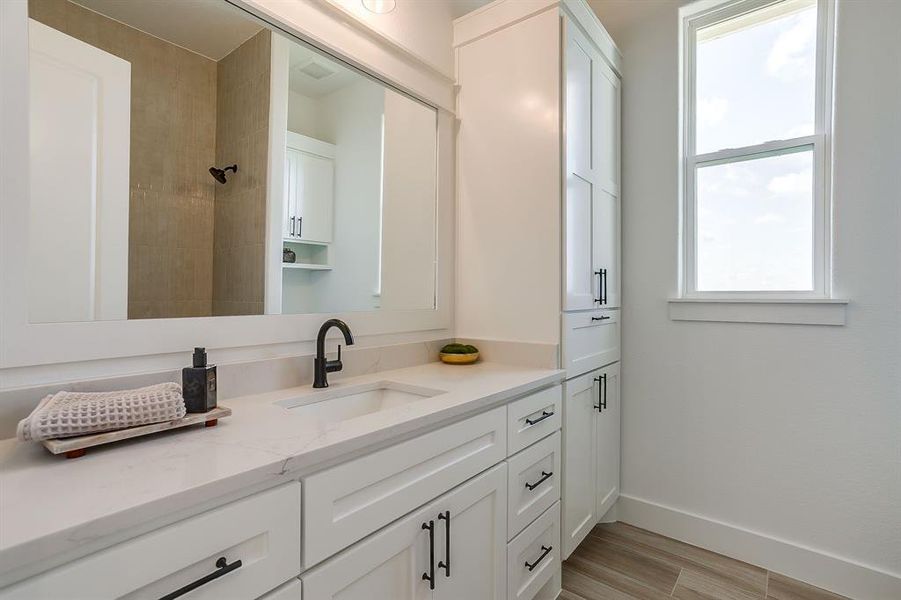 Secondary Bathroom with floor to ceiling luxury tile in the bathtub surround