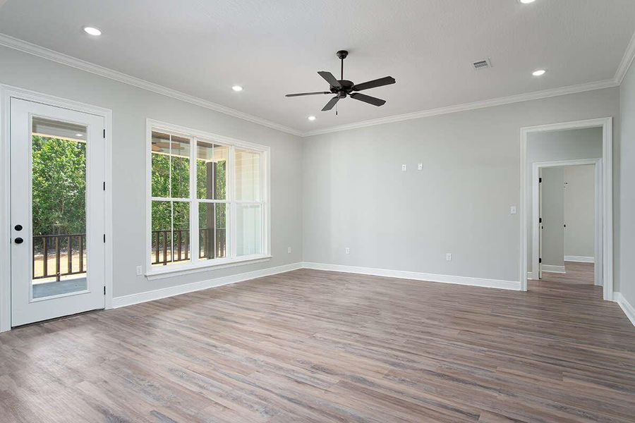Unfurnished room with wood finished floors, ornamental molding, baseboards, and ceiling fan