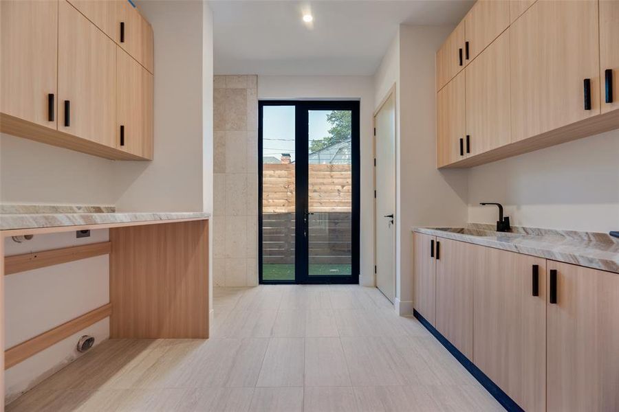 Kitchen with light stone countertops, light brown cabinetry, and light tile patterned floors