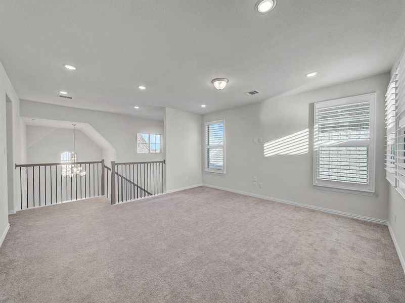 Empty room featuring carpet floors and a notable chandelier