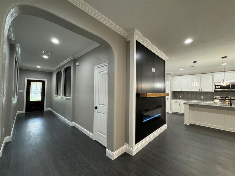 Hall with dark hardwood / wood-style flooring, crown molding, and sink